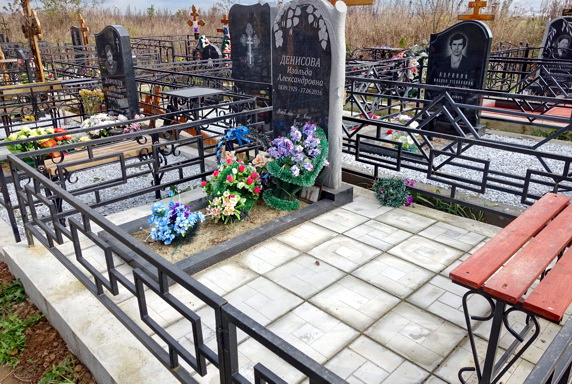 Простое место захоронения с резным памятником